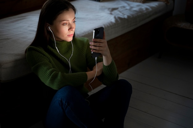 Mulher ouvindo música e olhando para o smartphone