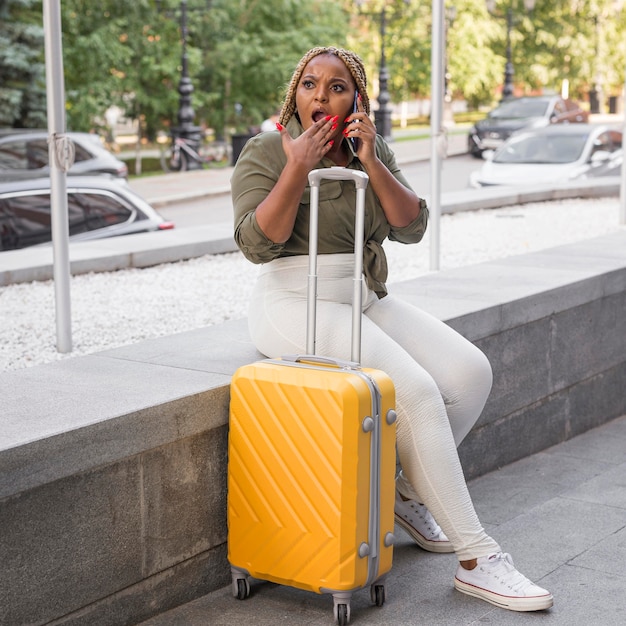 Mulher parecendo chocada enquanto fala ao telefone lá fora