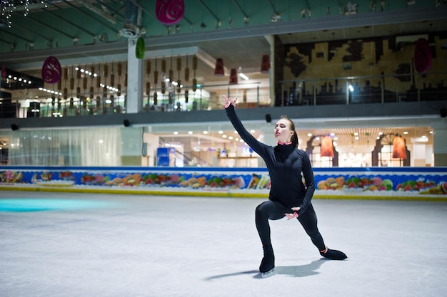 Mulher patinadora artística na pista de patinação no gelo