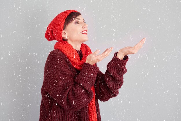 Mulher pegando pedaços da primeira neve