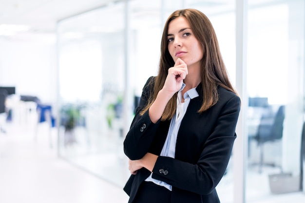 Mulher pensativa com a mão no queixo