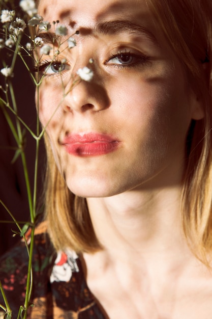 Foto grátis mulher pensativa com ramo de flor branca