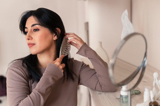 Mulher penteando o cabelo durante sua rotina de beleza