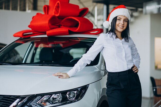 Mulher perto do carro com laço vermelho