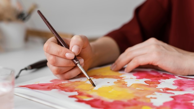 Mulher pintando com aquarela sobre papel