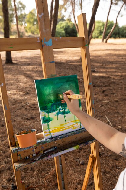 Mulher pintando paisagem na tela ao ar livre