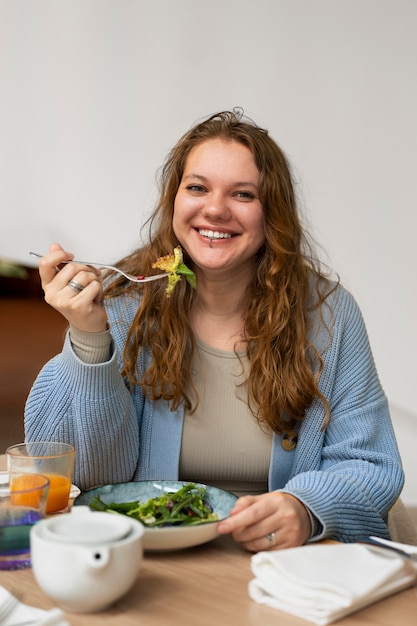 Mulher plus size comendo sozinha em um restaurante