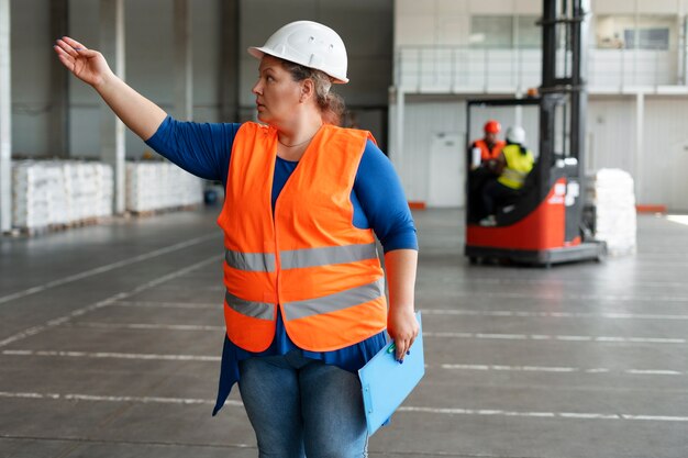 Mulher plus size de tiro médio trabalhando na construção