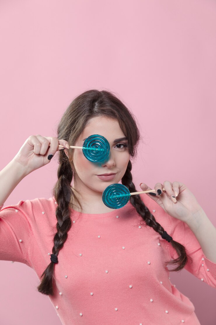 Foto grátis mulher posando ao cobrir o olho com pirulito