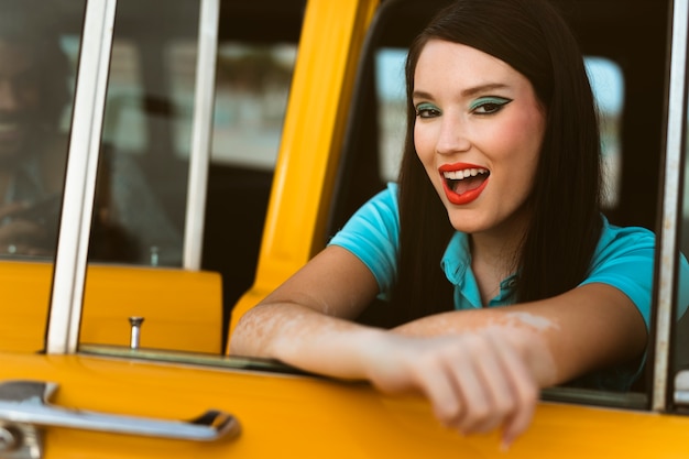 Mulher posando em estilo retrô ao lado do carro