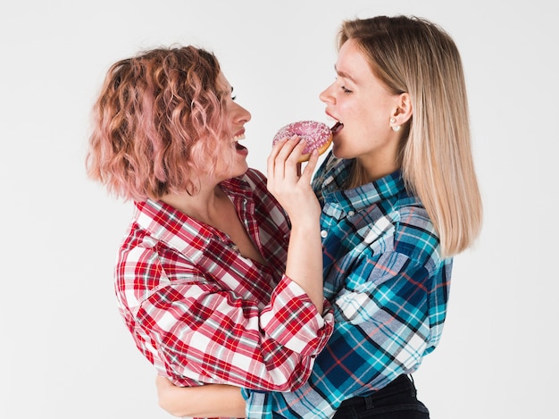 Foto grátis mulher posando enquanto come rosquinha para dia dos namorados