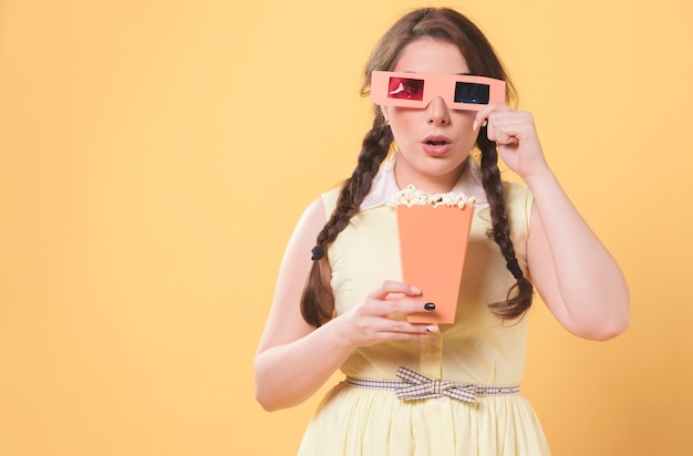 Foto grátis mulher posando enquanto usava óculos de cinema e segurando pipoca