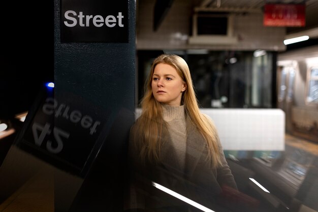 Mulher posando enquanto viaja no metrô da cidade