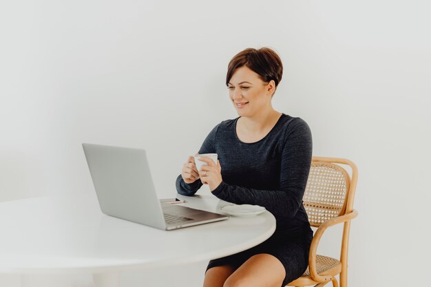 Foto grátis mulher positiva com uma xícara de chá teletrabalho