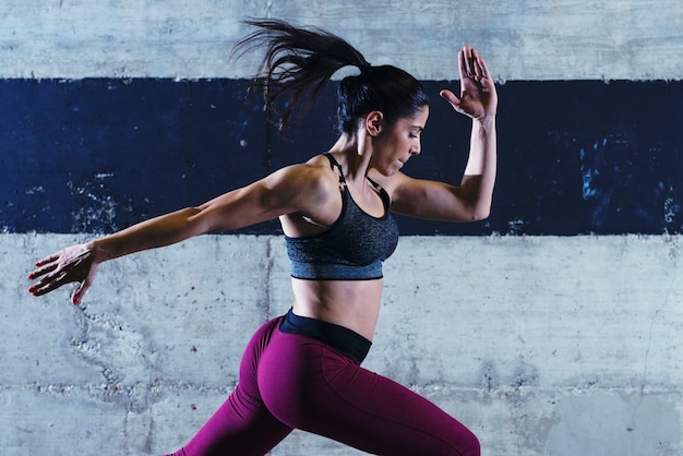 Mulher praticando exercícios pulando na academia