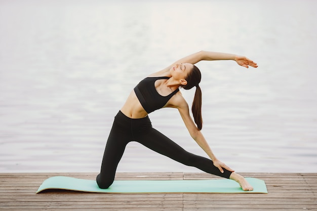 Mulher praticando ioga avançada pela água