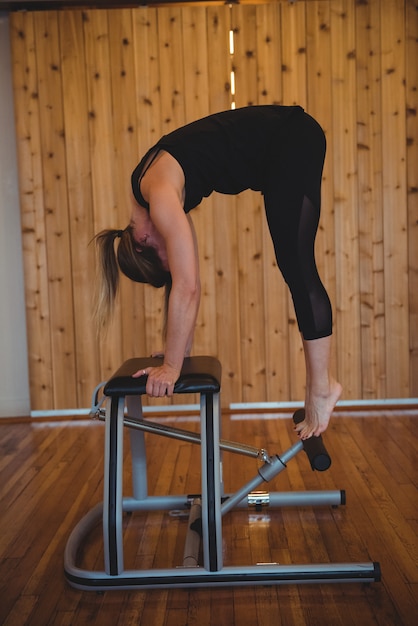 Mulher praticando pilates em estúdio de fitness