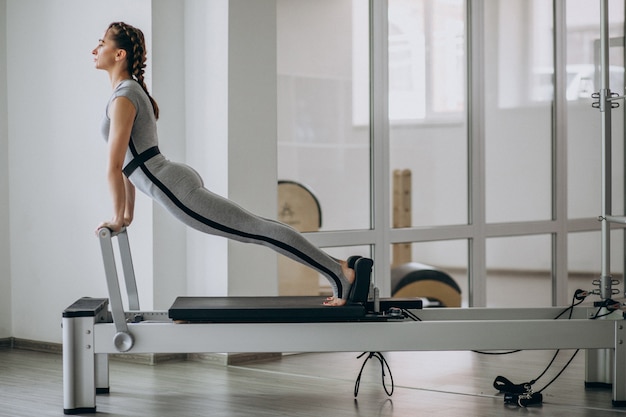 Foto grátis mulher praticando pilates em um reformador de pilates