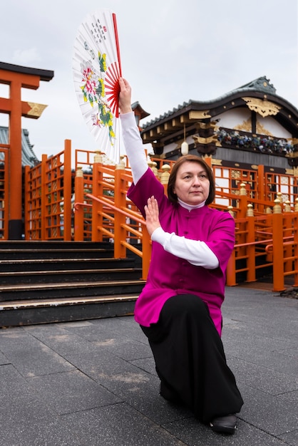 Mulher praticando tai chi ao ar livre tiro completo