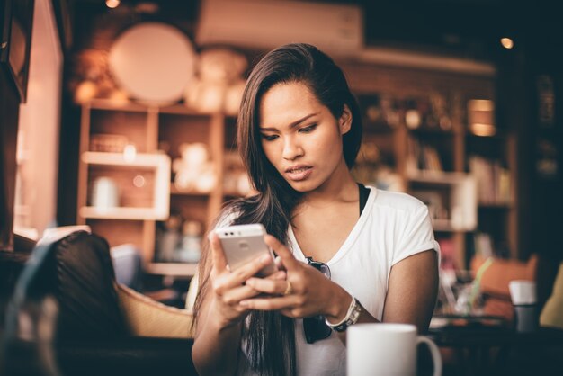 Mulher preocupada que olha seu telefone