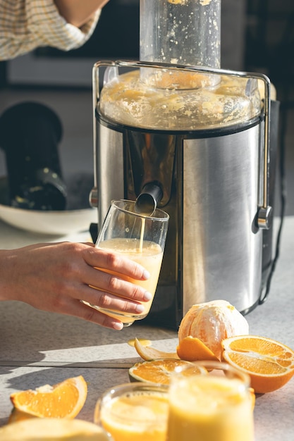 Foto grátis mulher preparando suco de laranja fresco para o café da manhã na cozinha