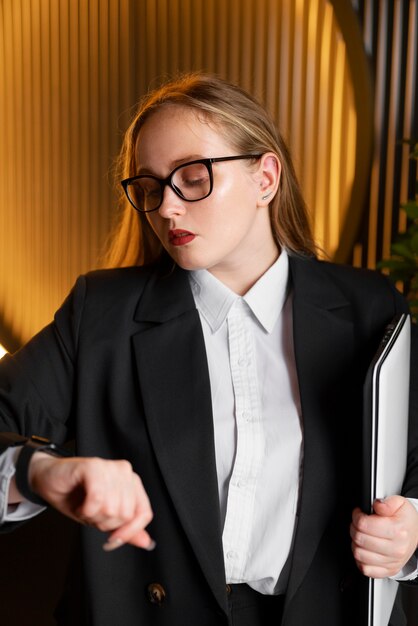 Mulher profissional em terno elegante no escritório com laptop