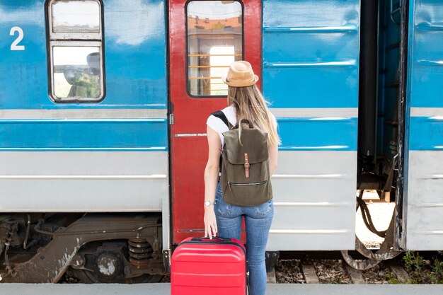 Mulher pronta para pegar o trem por trás