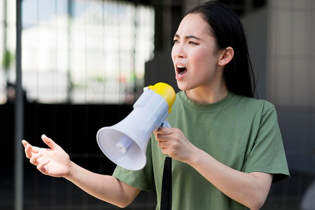 Mulher protestando e falando no megafone