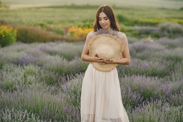 Mulher provençal relaxante no campo de lavanda. Senhora com um chapéu de palha.