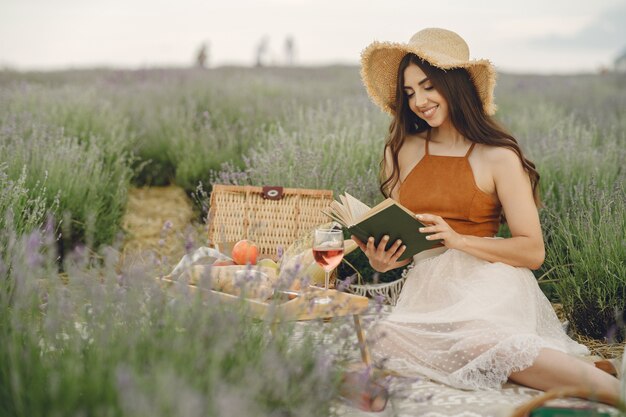 Mulher provençal relaxante no campo de lavanda. Senhora em um piquenique.