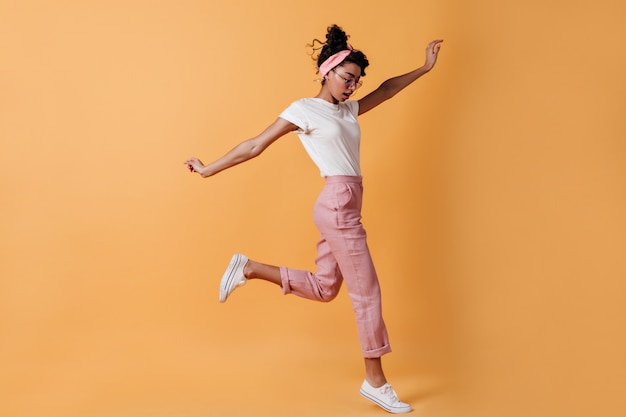 Mulher pulando com calça rosa