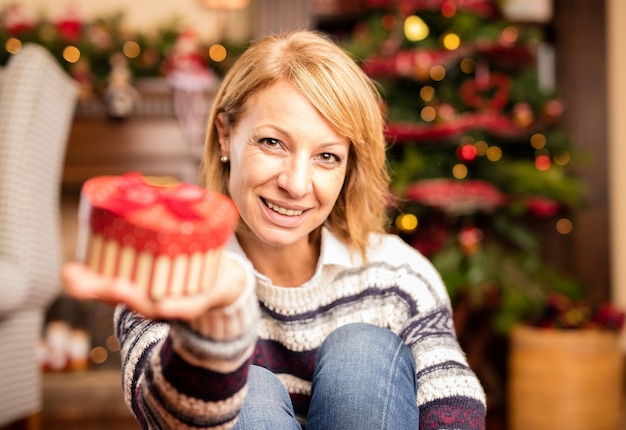 Mulher que abre um presente de natal