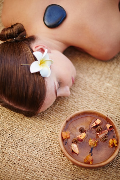 Foto grátis mulher que aprecia uma massagem com pedras quentes