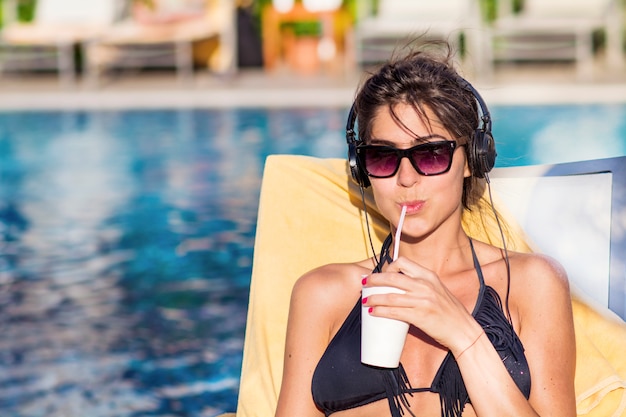 Foto grátis mulher que bebe um refrigerante enquanto ouve música