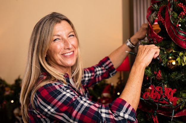 Mulher que decora a árvore de Natal