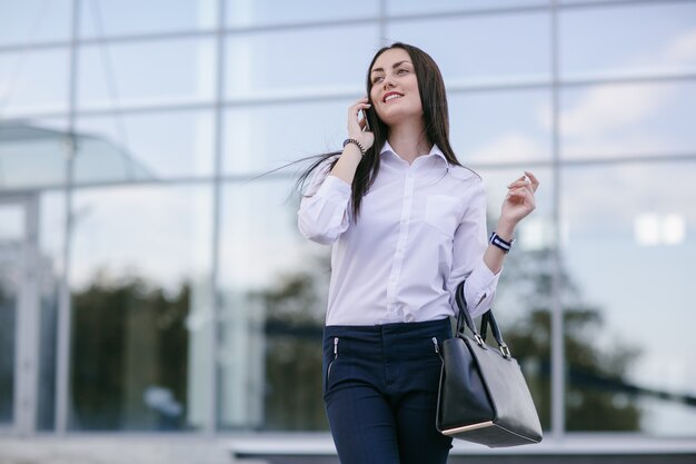 Mulher que fala em um telefone móvel, enquanto sorrindo