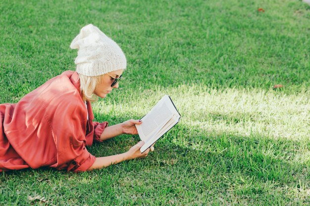 Mulher que gosta de livro na grama