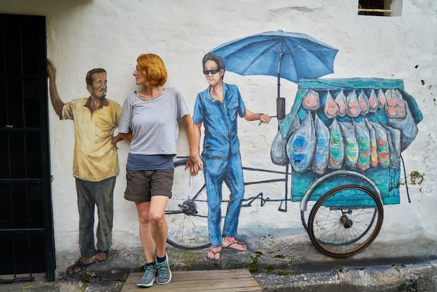 Mulher que levanta na frente de um grafitti