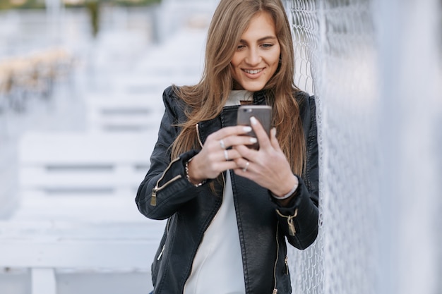 Mulher que olha seu smartphone e sorrisos