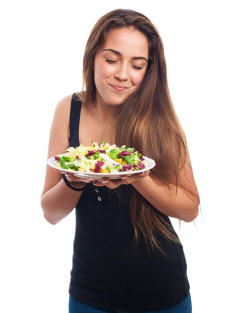 Mulher que olha sua salada com dessire