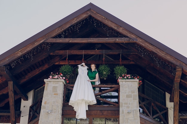 Mulher que prende o vestido de casamento