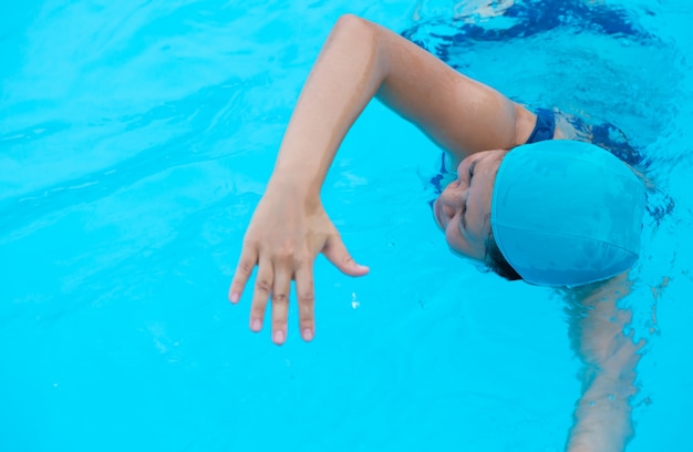 Mulher que relaxa na piscina