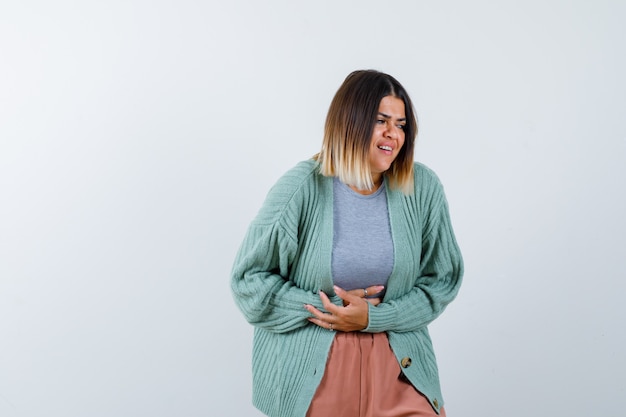 Foto grátis mulher que sofre de dor de estômago em roupas casuais e parece dolorida. vista frontal.