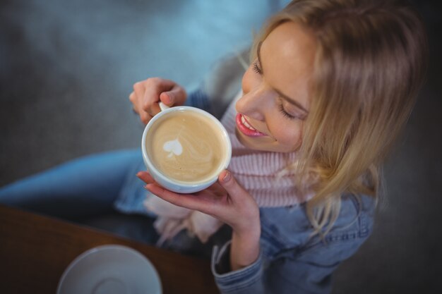 Mulher que tem uma chávena de café no cafÃ ©