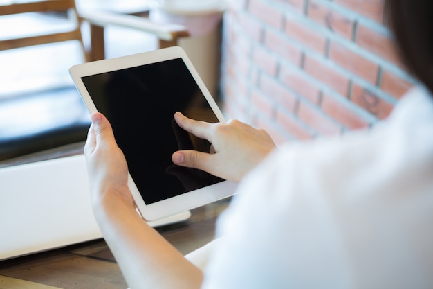 Mulher que toca a tela de seu tablet