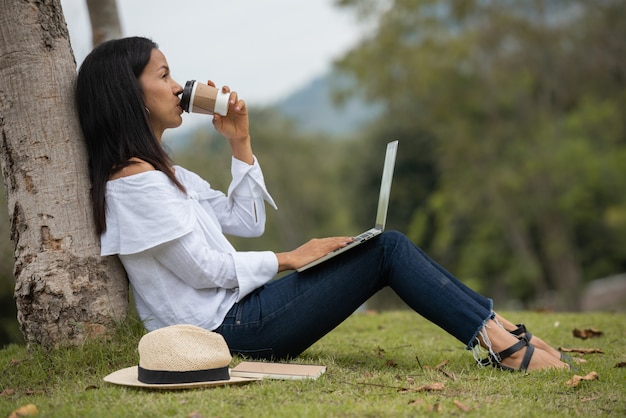 mulher que trabalha em um laptop na natureza