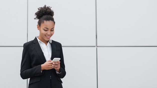 Mulher que verifica o telefone tiro médio