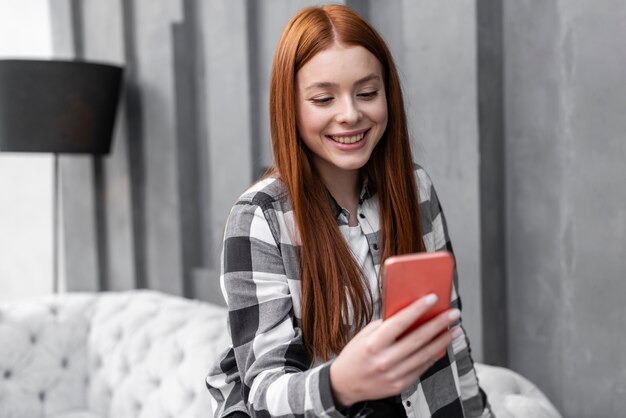 Mulher que verifica o telefone tiro médio