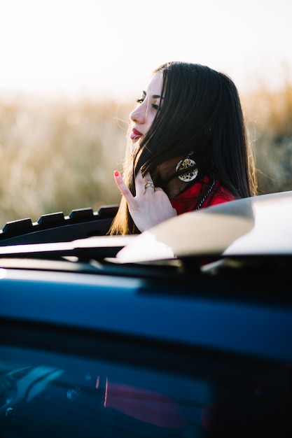 Foto grátis mulher reajustando o cabelo perto do carro