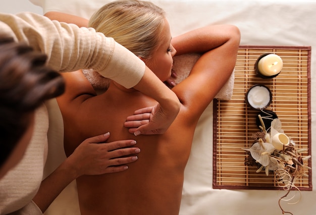Mulher recebendo massagem relaxante em vista de alto ângulo do salão de beleza Foto gratuita